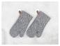 Deux maniques grises rayées accrochées à des crochets muraux.