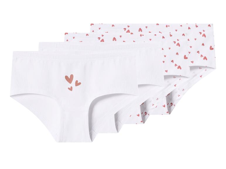 Quatre culottes blanches pour enfants, deux avec de petits cœurs rouges, deux avec quelques cœurs plus grands.