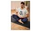 Un homme en t-shirt blanc avec l'inscription 'Sweat Recover Repeat' est assis en position de lotus sur un tapis de yoga.