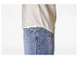 Witte blouse en blauwe jeans, met zichtbare stiksels en een metalen klinknagel.