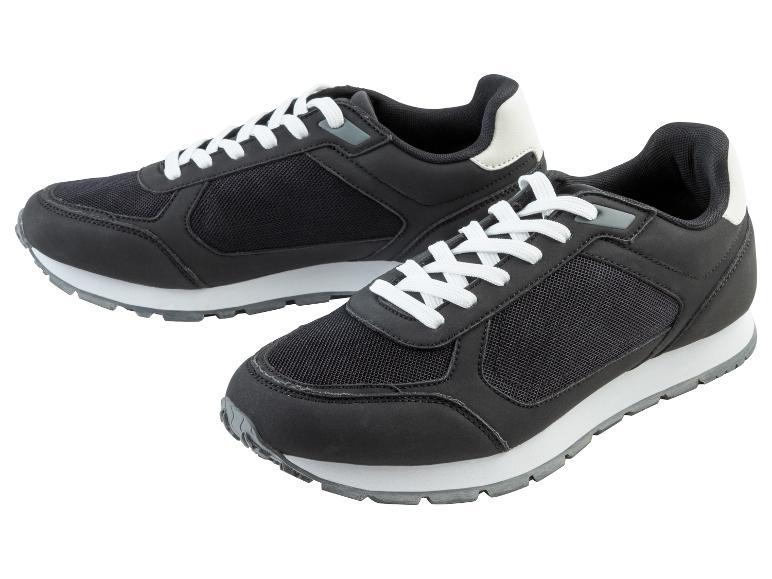 Twee zwarte sneakers met witte veters.
