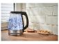 Silvercrest waterkoker met kokend water, glas en koekjes op een houten aanrecht.