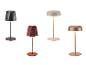 Vier draagbare tafellampen met diverse ontwerpen en kleuren, waaronder zwart, terracotta, beige en koper.