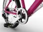 Close-up van het achterwiel, de ketting, pedalen en het versnellingssysteem van een roze fiets.