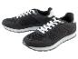 Twee zwarte sneakers met witte veters.