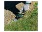 Gehandschoende hand gebruikt Parkside accugrasschaar om gras te trimmen