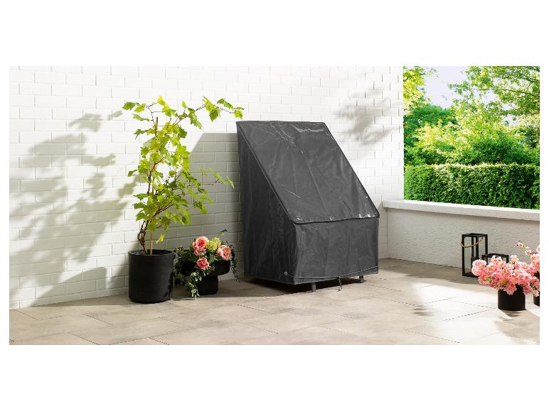 Een grijze beschermhoes voor een tuinstoel op een terras.
