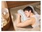 Un homme dort paisiblement sur un oreiller ergonomique.