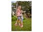 Twee kinderen in zomerkleding en schoenen knuffelen in een tuin.