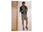 Homme en t-shirt vert, short cargo beige et baskets grises.