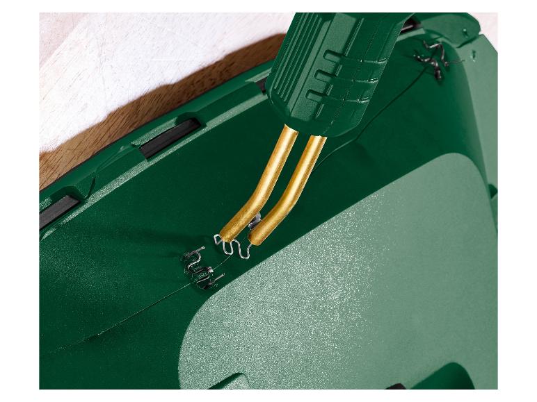 Close-up van een groene kunststoflasser met metalen nietjes die een scheur repareren.