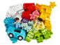 Un tas de briques LEGO DUPLO colorées avec deux figurines et une voiture.