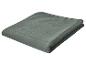 Couverture matelassée vert foncé pliée avec motif à carreaux.