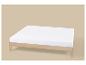 Eenvoudig licht houten bedframe met een wit matras op een beige achtergrond.