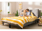Een stel ligt in bed met gestreept beddengoed.