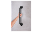 Een hand houdt een zwart wandbevestigd handvat vast.