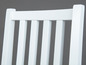 Le dossier d'une chaise en bois blanc.