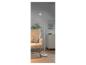 Moderne witte staande lamp naast een fauteuil.