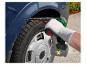 Un homme utilise une ponceuse avec une batterie pour réparer une voiture.