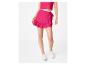 Vrouw in fuchsia roze crop top en ruches minirok, witte sneakers
