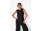 Femme portant un haut noir sans manches et un pantalon large.