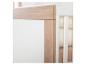 Close-up van een wit ledikant met houten details en zachte dekens.