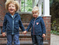 Deux enfants portant des vestes en polaire bleues avec une ancre et un cœur.