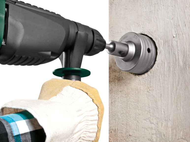 Een persoon gebruikt een boormachine met een diamantboor om een gat in beton te boren.