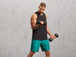 Man in sportkleding die dumbbells vast heeft.