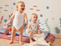 Twee baby's dragen schattige badpakjes met een maritiem thema.