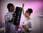 Un homme tient un haut-parleur Bluetooth portable noir lors d'une fête.