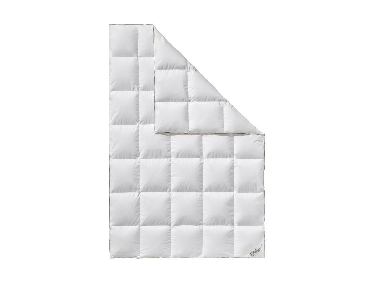 Wit gewatteerd dekbed met een gevouwen hoek, met een groen logo in de rechterbenedenhoek.
