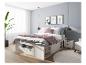 Chambre avec lit blanc de rangement, jeté de lit rose et murs gris.