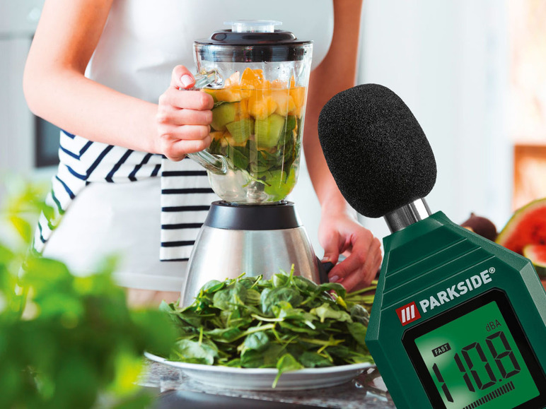 Een vrouw maakt een smoothie met een blender, terwijl een Parkside geluidsmeter de decibellen meet.