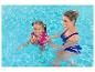 Femme et fille en gilet de natation coloré dans la piscine, souriantes.