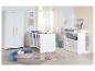Witte babykamer met ledikant, kledingkast en commode, met houten accenten.