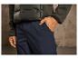 Un homme portant une veste vert foncé et un pantalon cargo bleu.