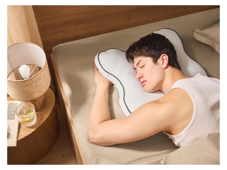 Un homme dort paisiblement sur un oreiller ergonomique.