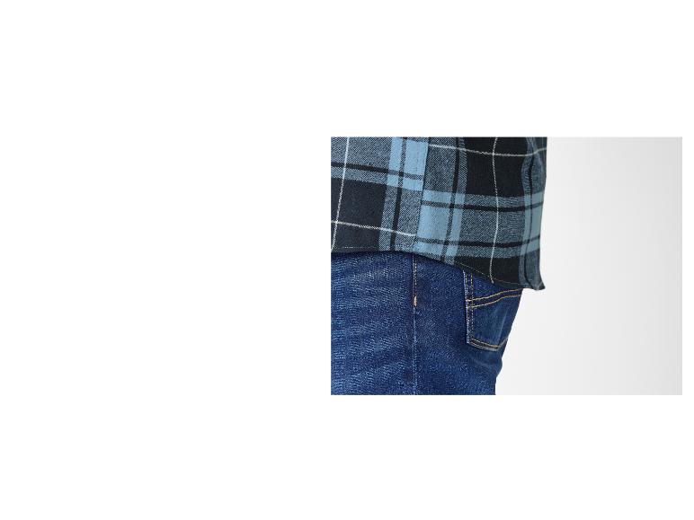 Gros plan sur une personne portant une chemise à carreaux bleue et noire et un jean.