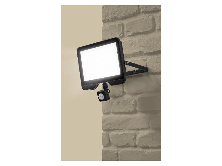 LED buitenlamp met bewegingssensor op een beige bakstenen muur.