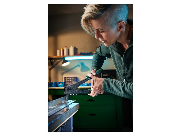 Een vrouw gebruikt een Parkside gereedschap om een metaalplaat te bevestigen.