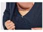 Een close-up van een donkerblauwe blouse met een knoop en een zichtbare bruine beha.