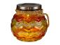 Een oranje glazen pot met een zonnepaneel en een touwtje.