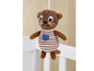 Une loutre en peluche marron avec des vêtements rayés, suspendue au-dessus d'un lit de bébé.