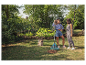 Deux femmes dans un jardin avec un râteau et des feuilles.