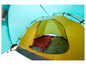Een gele tent met twee slaapzakken erin.