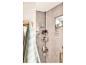 Driehoekige douchemand met shampoo en douchegel in een moderne badkamer.