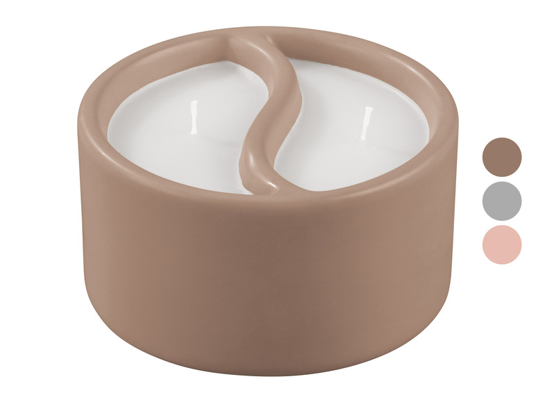 Bougie beige avec deux mèches en forme de yin-yang.