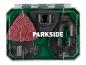 Multitool accessoire set met zaagbladen en schuurpapier in een groene koffer.