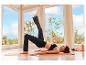 Une femme en legging de sport noir CRIVIT fait du yoga sur un tapis.